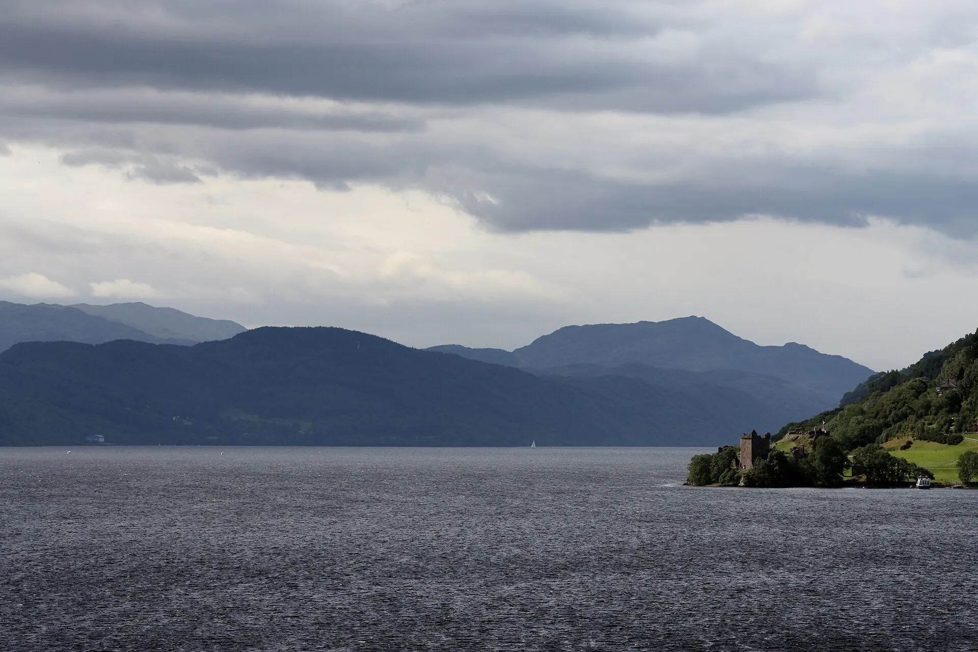 Daleka panorama Urquhart Castle i Loch Ness